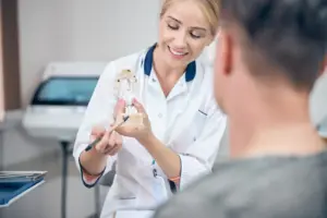 cheerful female dentist demonstrating jaw model to 2024 10 18 10 06 10 utc